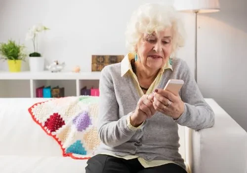 A grandmother using her phone to play solitaire